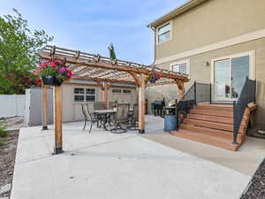 Rear view of house with a fenced backyard, a patio area, stucco siding, and a pergola