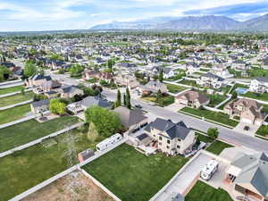 Aerial view of property and surrounding area with mountains and nearby suburban area