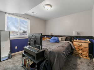 Bedroom with carpet floors, baseboards, and a textured ceiling