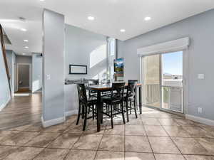 Tiled dining area with baseboards and recessed lighting