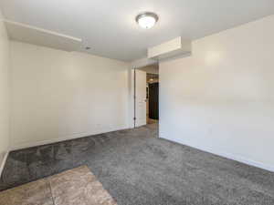 Carpeted spare room featuring baseboards