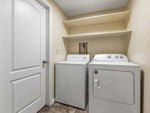 Washroom featuring separate washer and dryer and baseboards