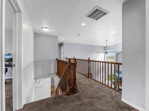 Hall featuring carpet floors, an upstairs landing, and recessed lighting