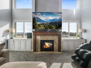Living room featuring carpet and a high end fireplace