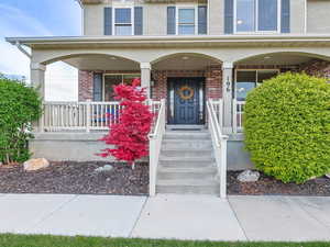 Entrance to property featuring covered porch and brick siding