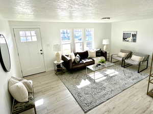 Living area with a textured ceiling and wood finished floors