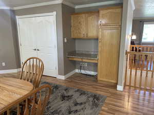 Dining space with baseboards, wood finished floors, and ornamental molding