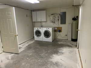 Washroom with cabinet space, washer and clothes dryer, and electric panel