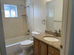 Full bath with toilet, vanity, bathtub / shower combination, and tile patterned flooring