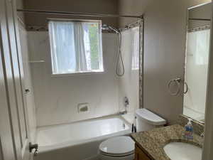 Full bath featuring toilet,  shower combination, and vanity