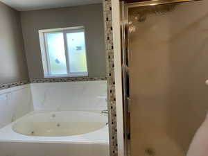 Bathroom featuring a stall shower and a jetted tub