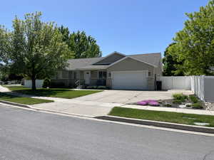 Ranch-style home featuring an attached garage, concrete driveway, stucco siding, and roof with shingles