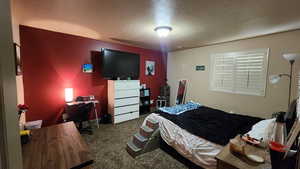 Bedroom with carpet floors and a textured ceiling