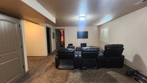 Carpeted cinema room featuring baseboards