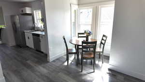 Dining space with dark wood-type flooring and baseboards