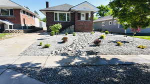 View of front of property featuring brick siding and a chimney