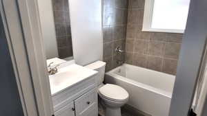 Bathroom featuring toilet, vanity, and shower / washtub combination