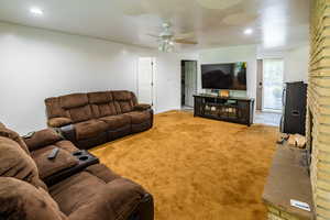 Carpeted living room with a ceiling fan and recessed lighting