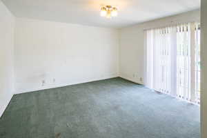 Upstairs bedroom  with carpet flooring and walk our balcony