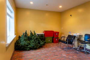 Misc room featuring plenty of natural light, brick floors, and recessed lighting