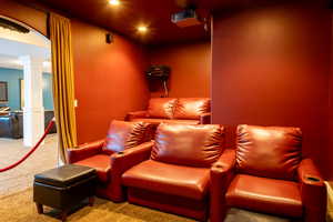 Carpeted home theater room with decorative columns and recessed lighting
