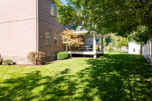 View of grassy yard featuring a deck