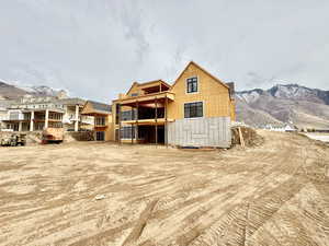 Back of house featuring a mountain view and a balcony