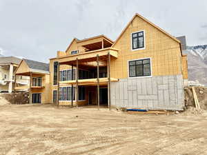 Back of property featuring a balcony and a patio area