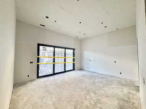 Empty room with concrete flooring and a high ceiling