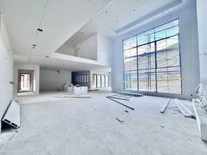 Unfurnished living room featuring a high ceiling