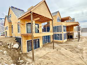 Back of property with a balcony and a patio area