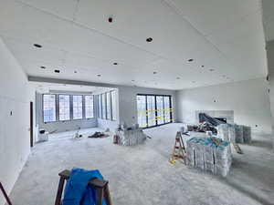 Miscellaneous room with a fireplace and unfinished concrete floors