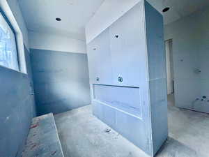 Miscellaneous room featuring heating unit and unfinished concrete flooring