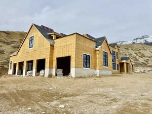 View of side of property featuring a mountain view and solar panels