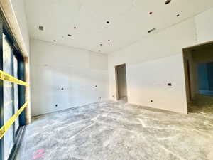 Unfurnished room with unfinished concrete flooring
