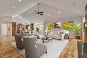 Living room with light wood-style flooring, arched walkways, plenty of natural light, recessed lighting, and high vaulted ceiling