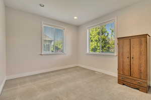 Spare room featuring carpet floors, baseboards, and recessed lighting