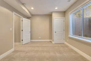 Unfurnished room with light colored carpet, recessed lighting, baseboards, and a smoke detector