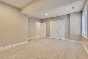 Unfurnished bedroom with baseboards, light colored carpet, recessed lighting, and a closet