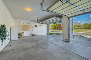 Garage with freestanding refrigerator, a mountain view, and a garage door opener