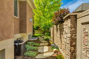View of side of property with central AC unit, stucco siding, and fence