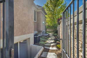 View of side of property featuring central air condition unit and stucco siding
