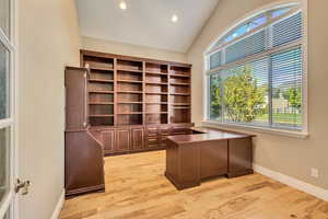 Unfurnished office featuring baseboards, light wood-type flooring, recessed lighting, and lofted ceiling