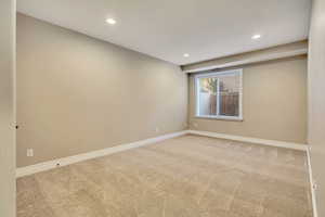Carpeted spare room with baseboards and recessed lighting