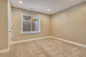 Carpeted empty room with baseboards and recessed lighting