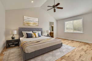 Bedroom with vaulted ceiling, light wood-style floors, baseboards, connected bathroom, and ceiling fan