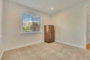 Carpeted spare room with baseboards and recessed lighting