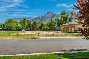 View of asphalt road featuring a mountain view and curbs