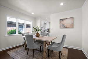 Dining area with crown molding, dark wood-style flooring, baseboards, a textured ceiling, and recessed lighting