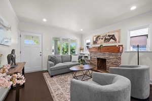 Living area featuring ornamental molding, dark wood-style flooring, a fireplace, recessed lighting, and baseboards